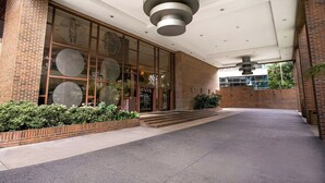A building entrance with a brick facade, large windows, and a modern ceiling design. - Renaissance Caracas La Castellana Hotel (Caracas)