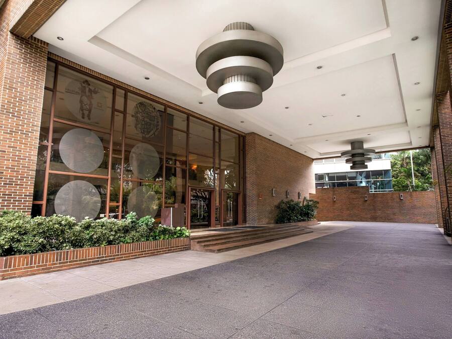 A building entrance with a brick facade, large windows, and a modern ceiling design.