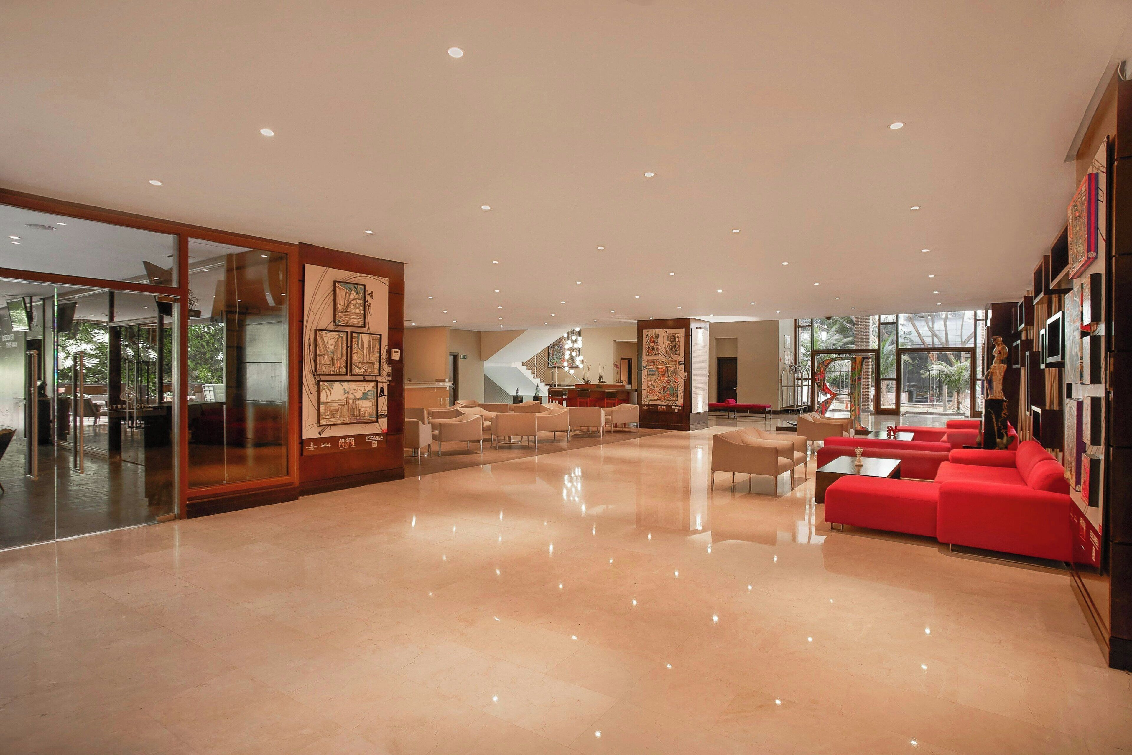 A spacious lobby with a polished floor, a staircase, and seating areas.