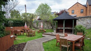 A wooden deck with picnic tables and chairs, a gazebo, and a stone wall. - The Hampton Hotel by Greene King Inns (Edinburgh)