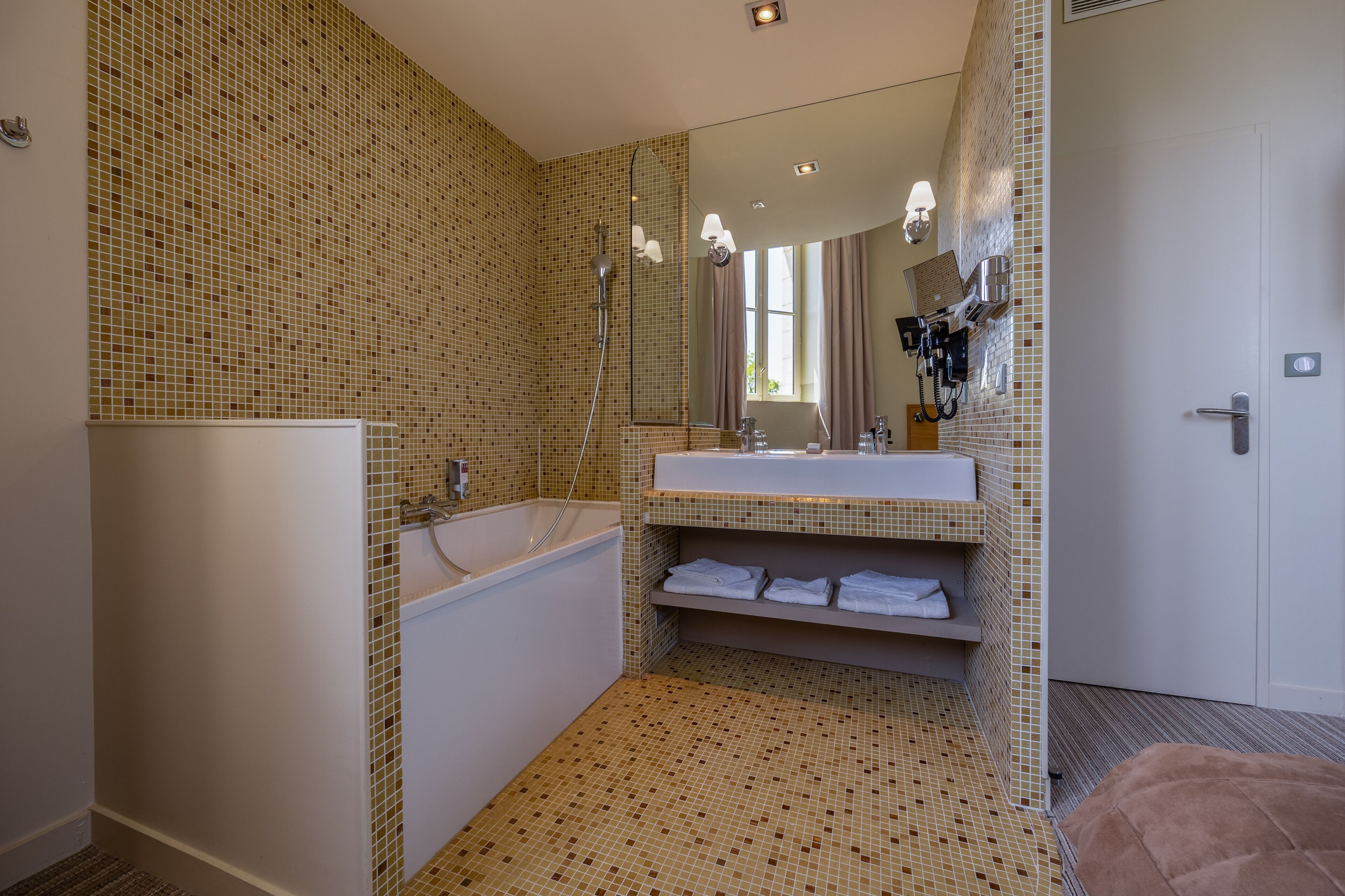 A modern bathroom with a bathtub, a sink, and a mirror.