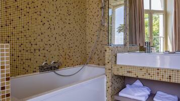 Een badkamer met een bad, douche en wastafel.