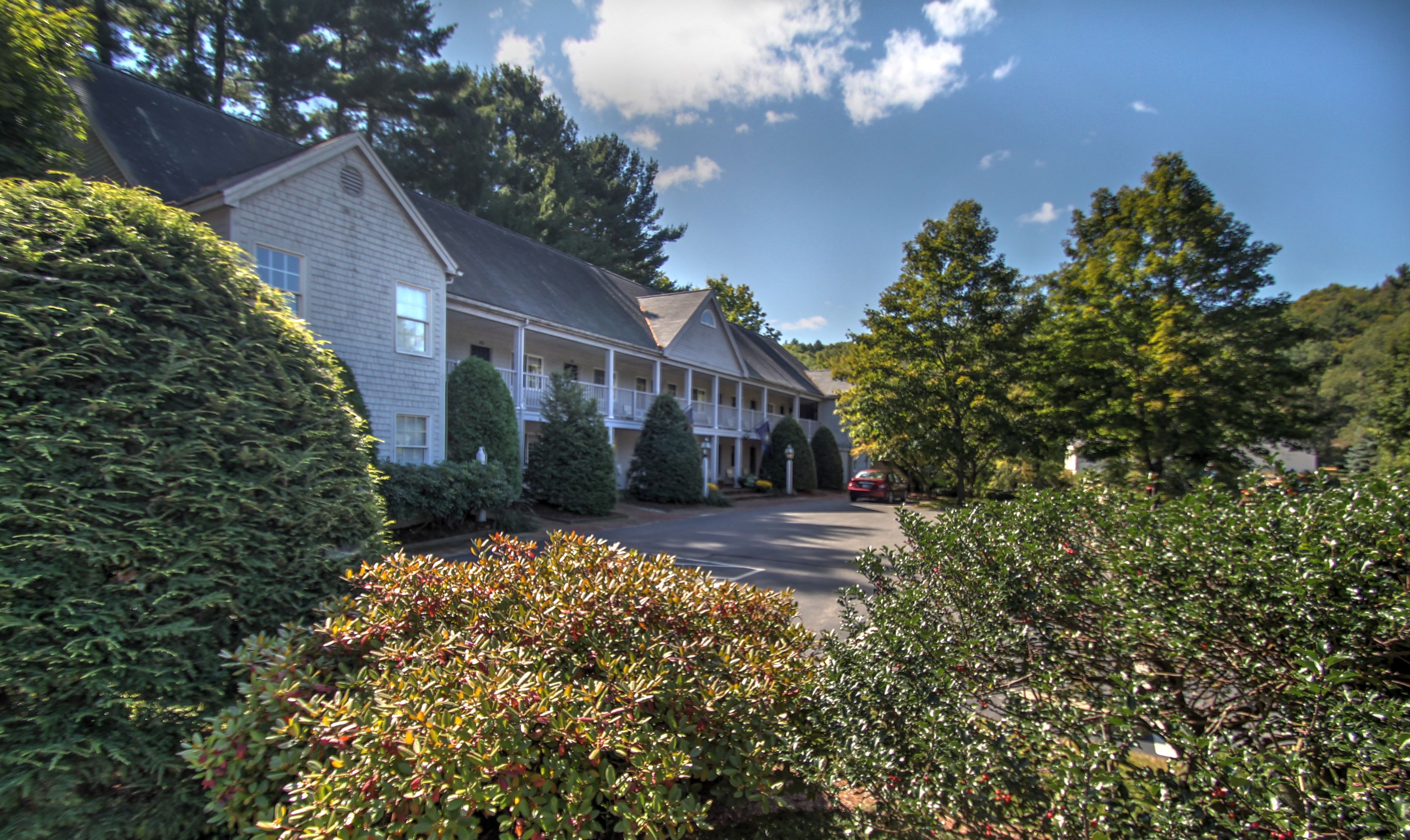 A two-story building with a porch and a driveway.