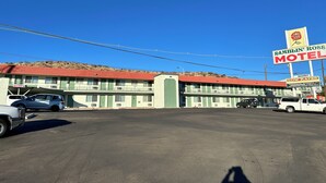 A Ramblin' Rose Motel with a red roof and a sign advertising low rates. - Ramblin Rose Motel (Kingman)