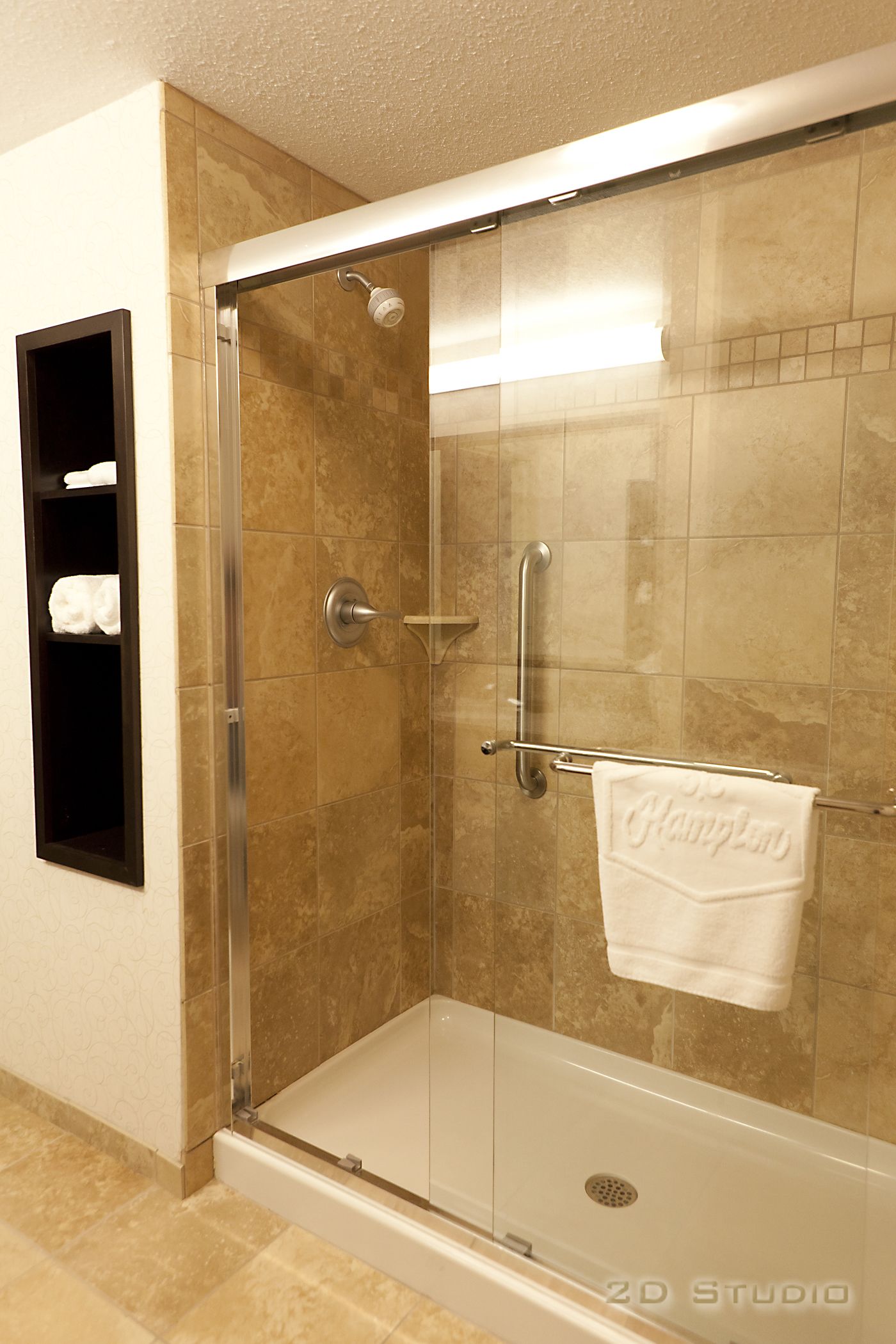 A glass-enclosed shower with a towel rack and a handrail.