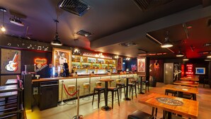 A bar area with a counter, stools, and tables. - Citymax Hotel Al Barsha at the Mall (Dubai)