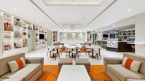 A modern hotel lobby with seating areas, a bar, and a CityMax store. - Citymax Hotel Al Barsha at the Mall (Dubai)