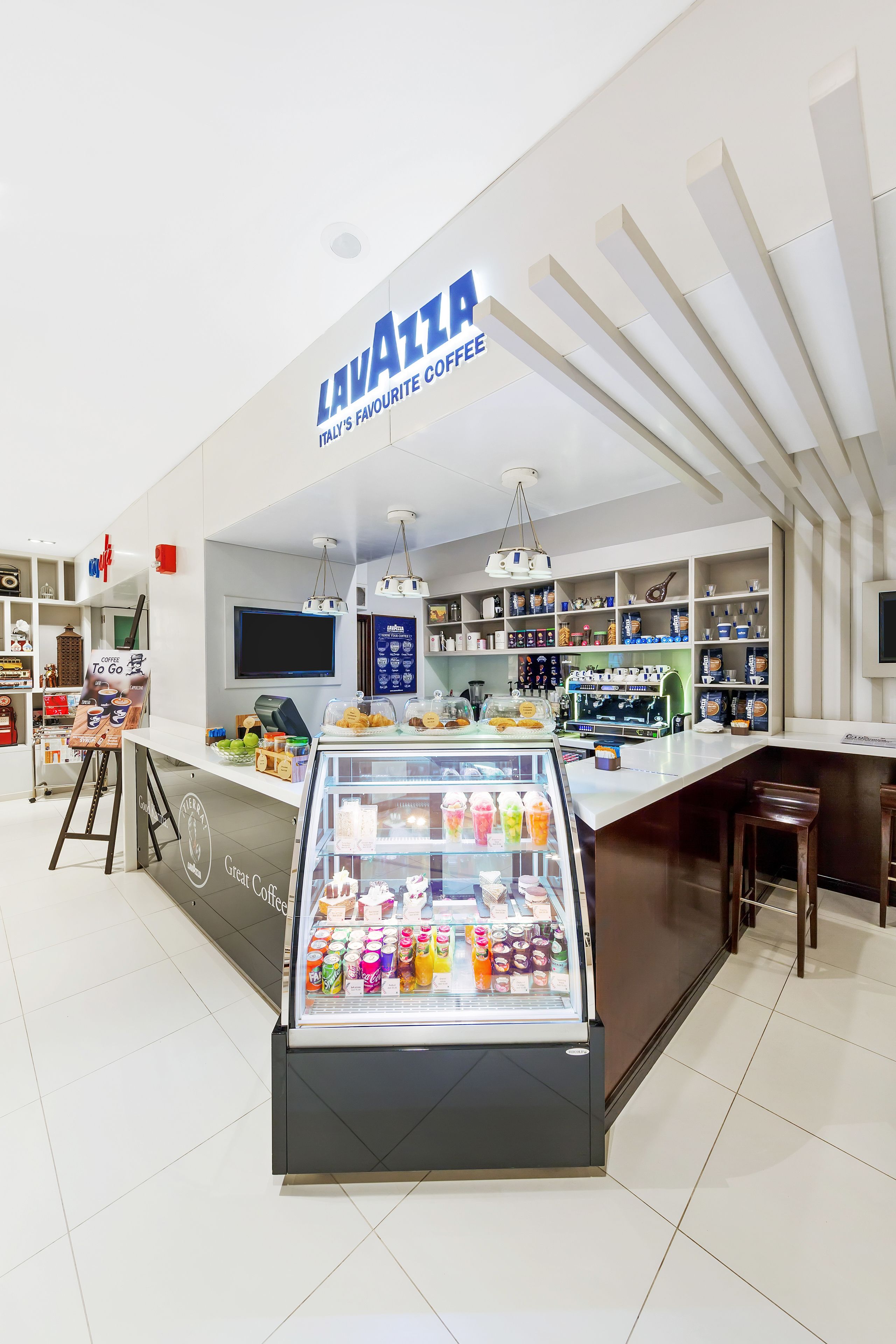 A coffee shop interior with a counter, display cases, and shelves stocked with products.