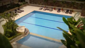 Alberca al aire libre y camastros