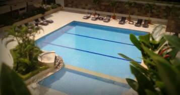 Una piscina al aire libre, sillones reclinables de piscina