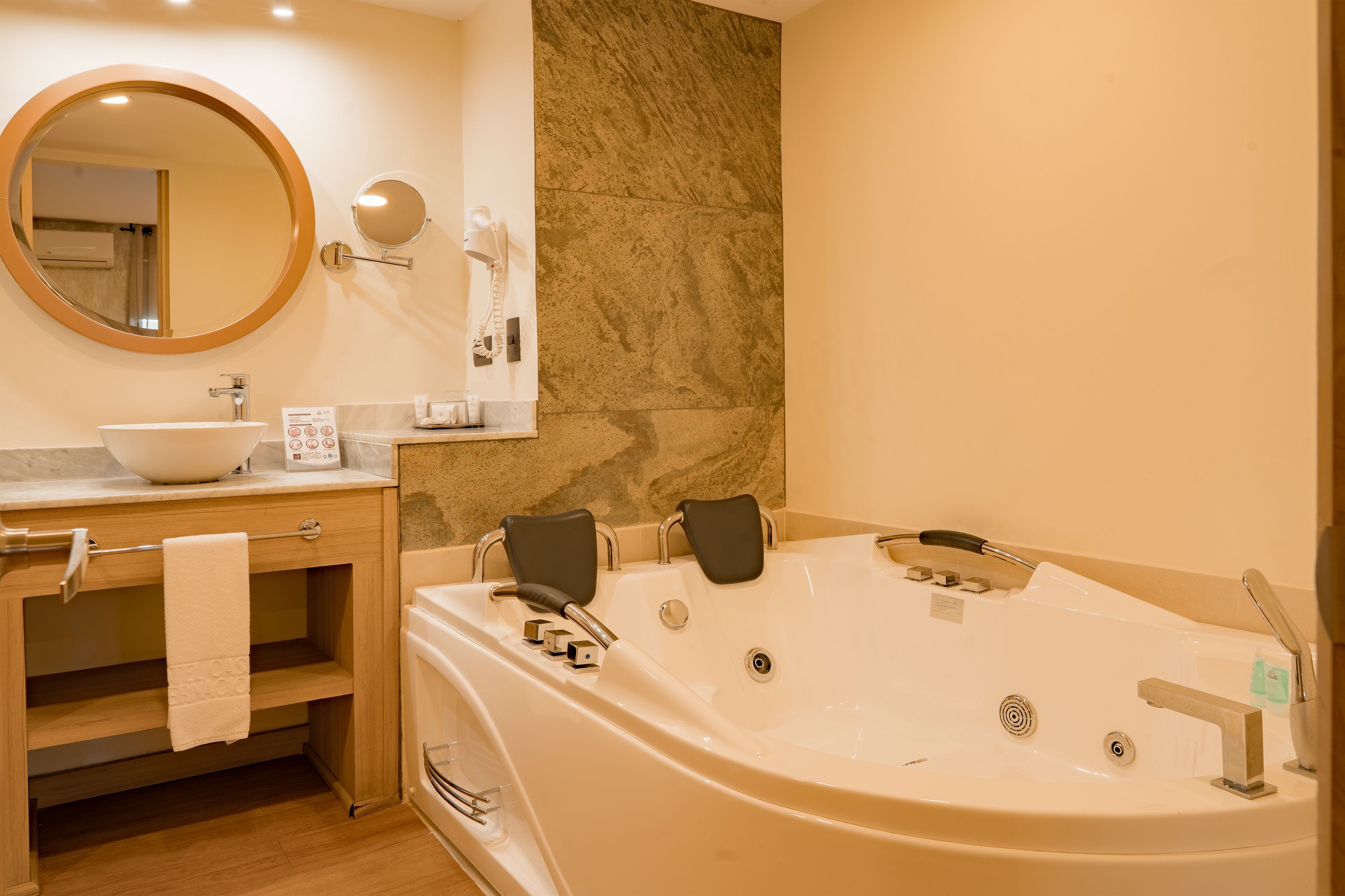 Ein Badezimmer mit Badewanne, Waschbecken, Spiegel und Handtuchhalter.