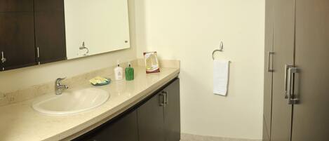 A bathroom with a sink, mirror, dark cabinets, and a towel rack.