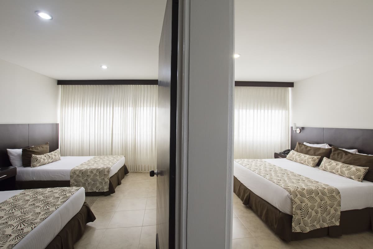 Ein Hotelzimmer mit zwei Betten, einem großen Fenster mit Vorhängen und einem modernen Design.