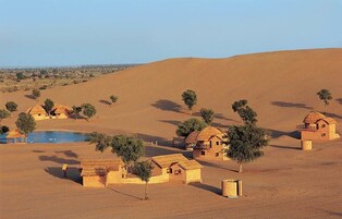 A desert landscape with small, traditional houses and sparse vegetation.