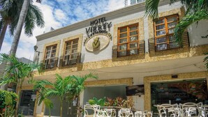 Hotel llamado "Hotel Virrey Cartagena" con asientos al aire libre y palmeras.