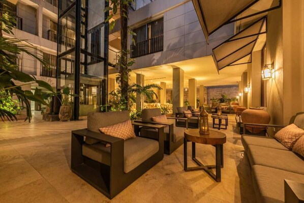 A modern outdoor lounge area with sofas, tables, and potted plants. - Madisson Boutique Hotel Cartagena (Cartagena)