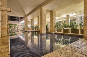 Una piscina techada, sillones reclinables de piscina