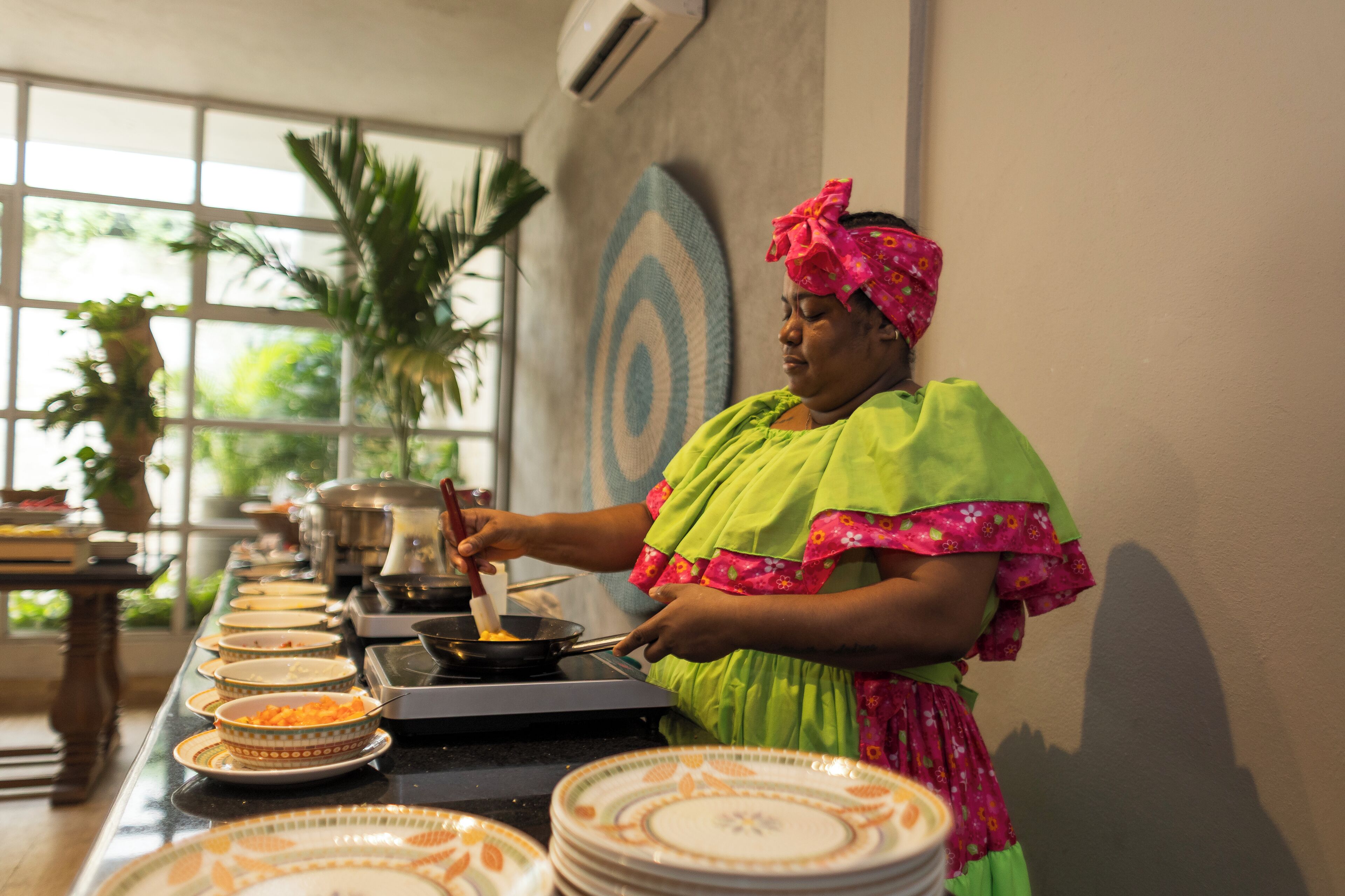 Un buffet proposant divers plats, avec une personne chargée de servir les aliments.