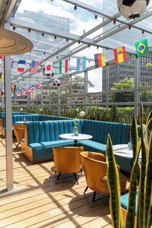 A restaurant with blue booths, yellow chairs, and flags of various countries. - ibis Bogota Museo (Bogotá)