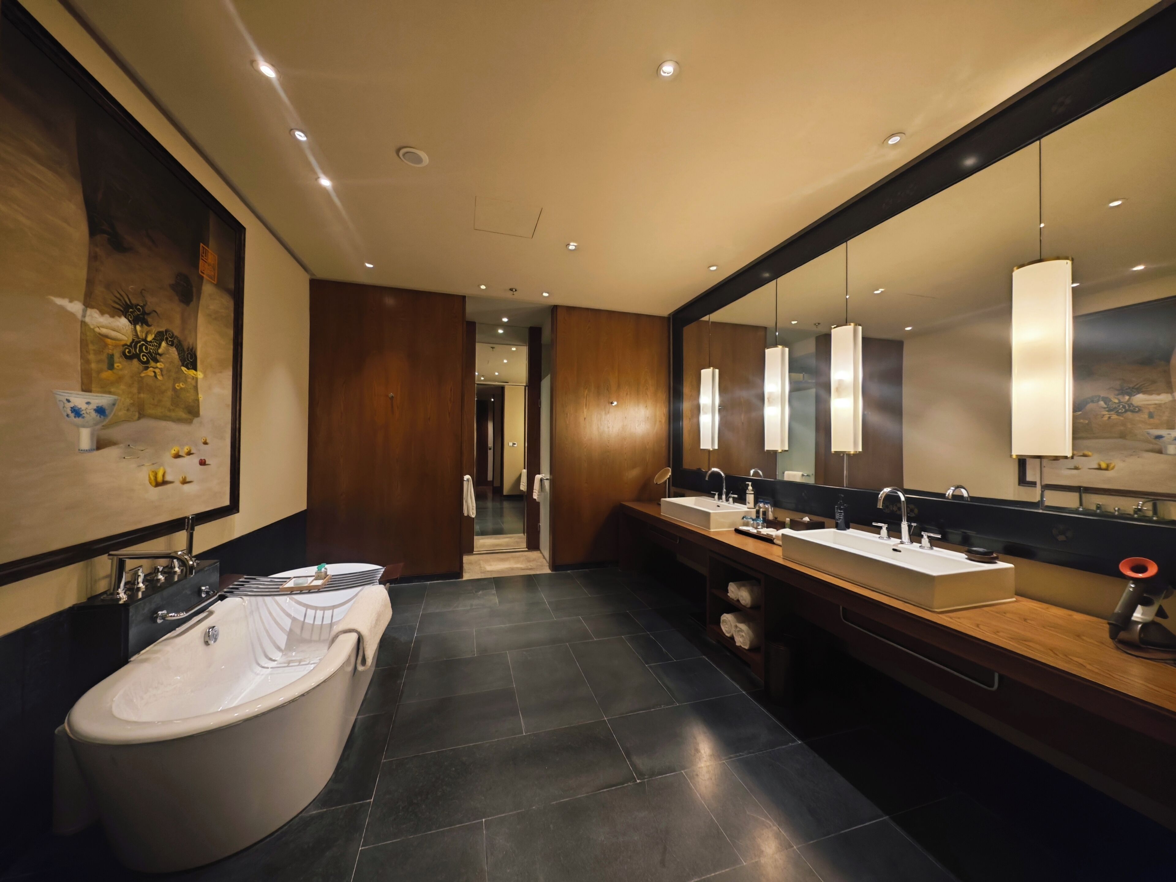 Ein modernes Badezimmer mit einer freistehenden Badewanne, zwei Waschbecken und einem großen Spiegel.