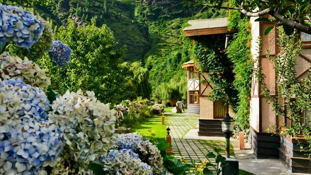 A garden pathway leading to a building with a wooden structure and a stone pathway. - Solang Valley Resort (Manali)