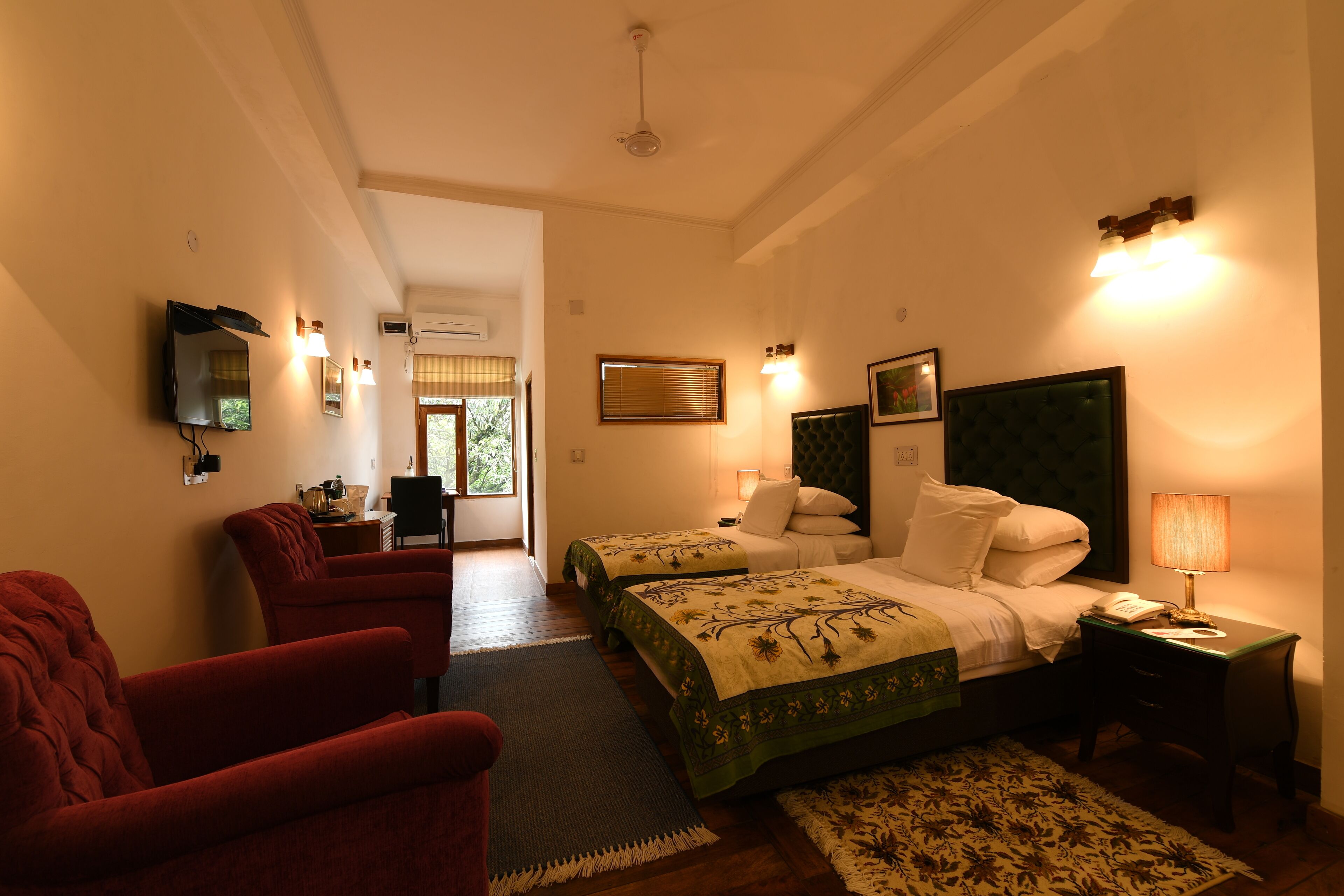 Une chambre d’hôtel avec deux lits, une télévision, un bureau et une chaise.