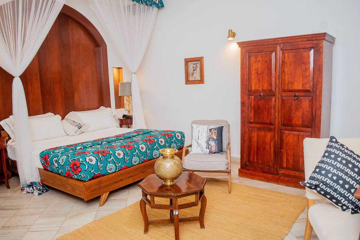 Un dormitorio con cama, mesita de noche, silla y armario.