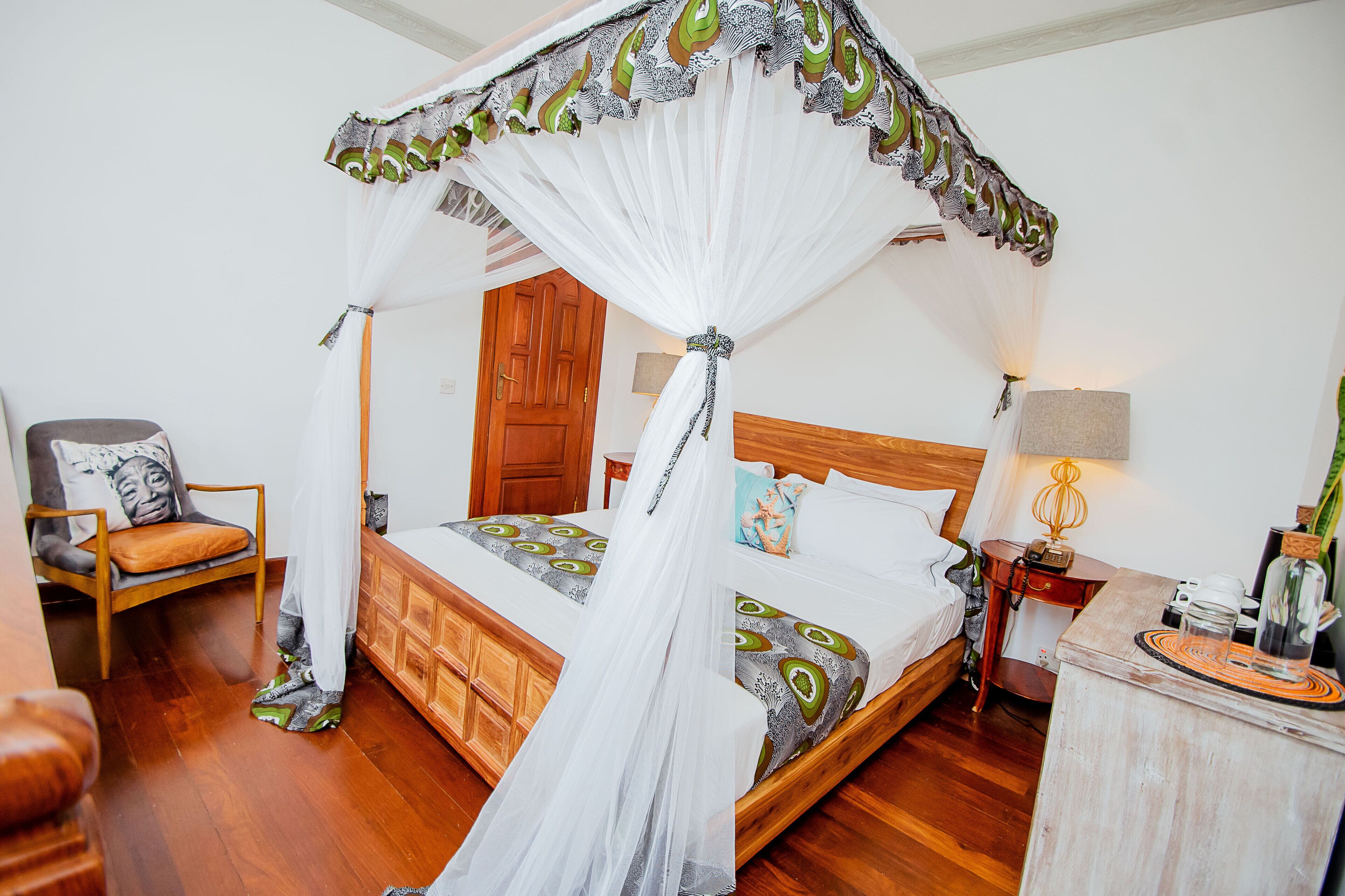 A bedroom with a wooden bed, a nightstand, a chair, and a wooden desk.
