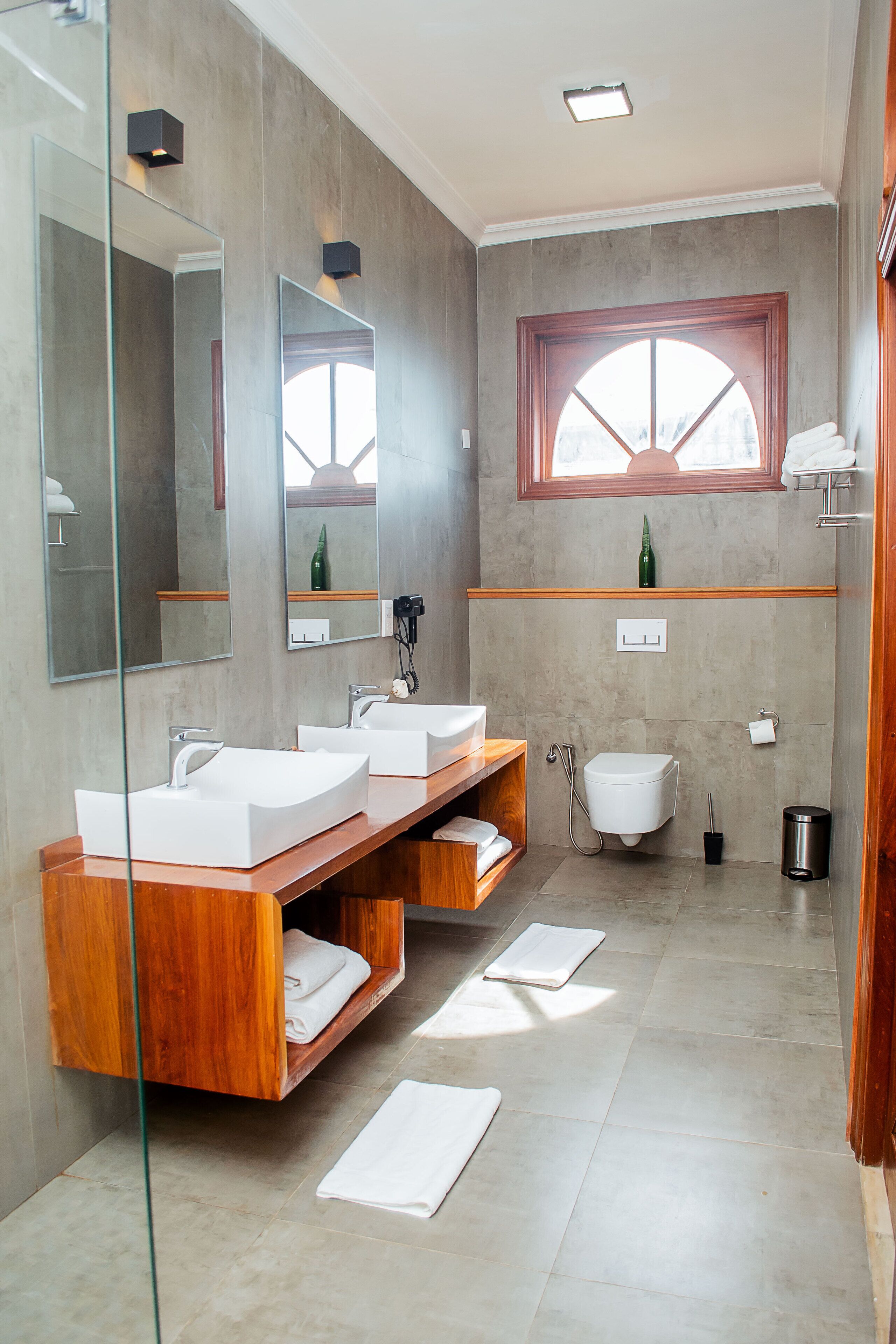 Un baño moderno con dos lavamanos, un inodoro y una ducha.