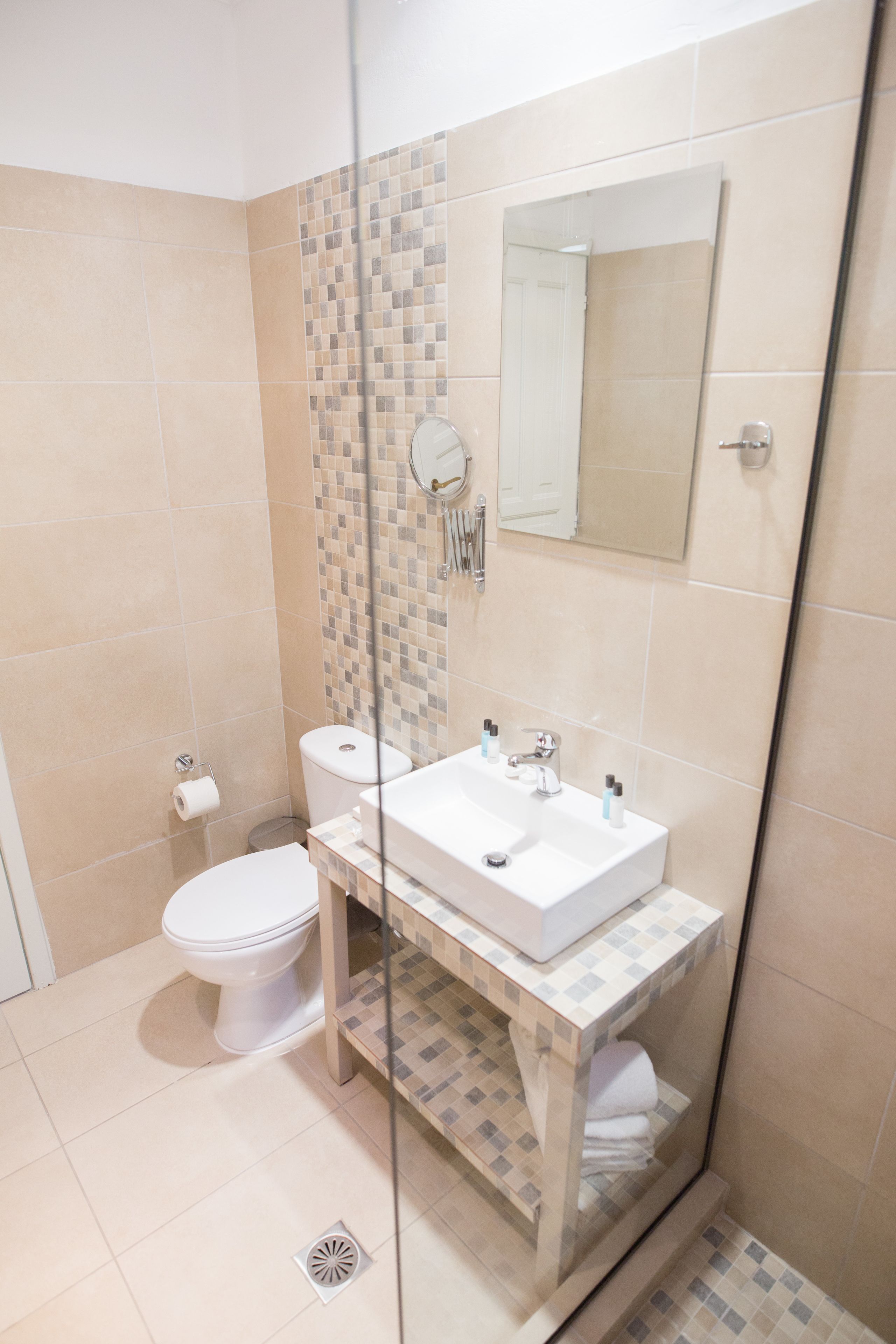 Une salle de bain comprenant des toilettes, un lavabo et un espace douche.