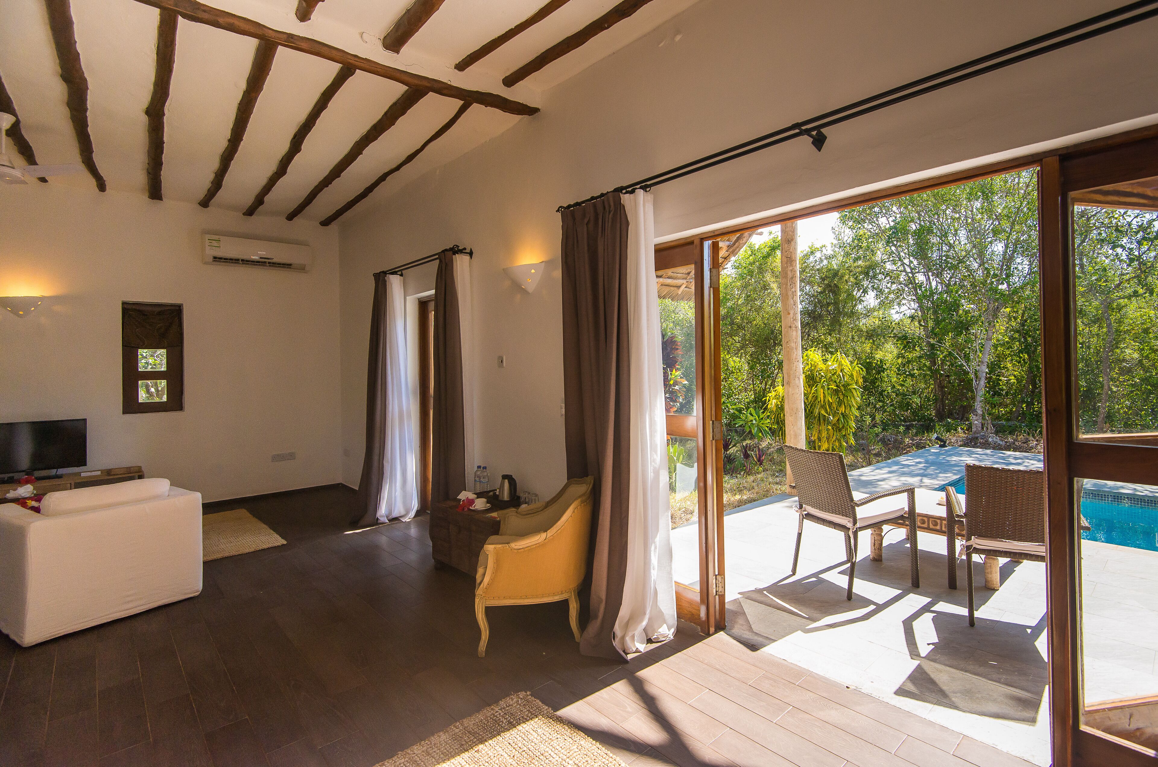 Amplia sala de estar con un gran ventanal corredero que da a un patio exterior con piscina.
