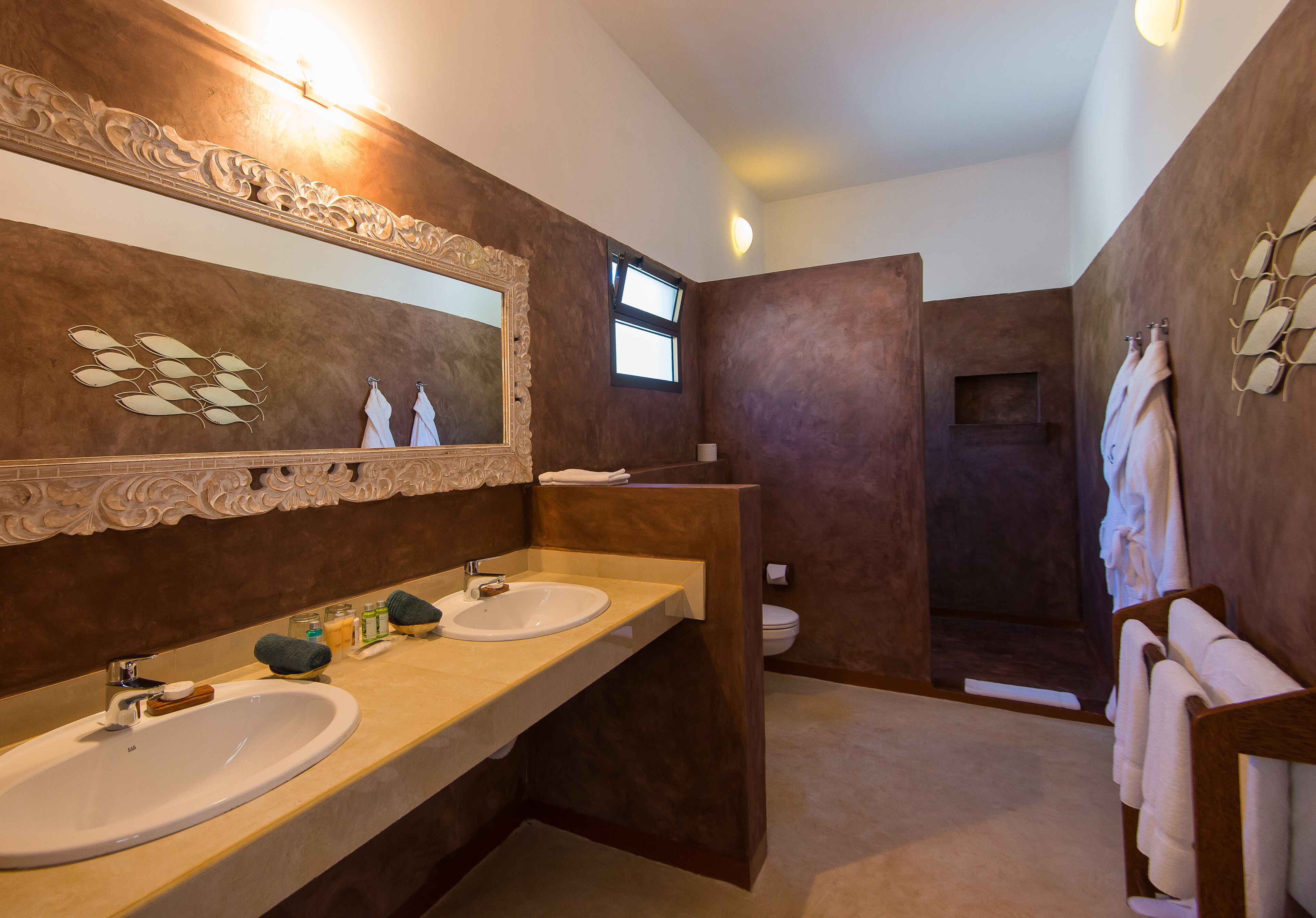 Un baño moderno con dos lavamanos, un espejo grande y un mueble de tocador de madera.