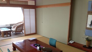 Una habitación japonesa tradicional con suelo de tatami, una mesa de madera, una silla y un puertas correderas.