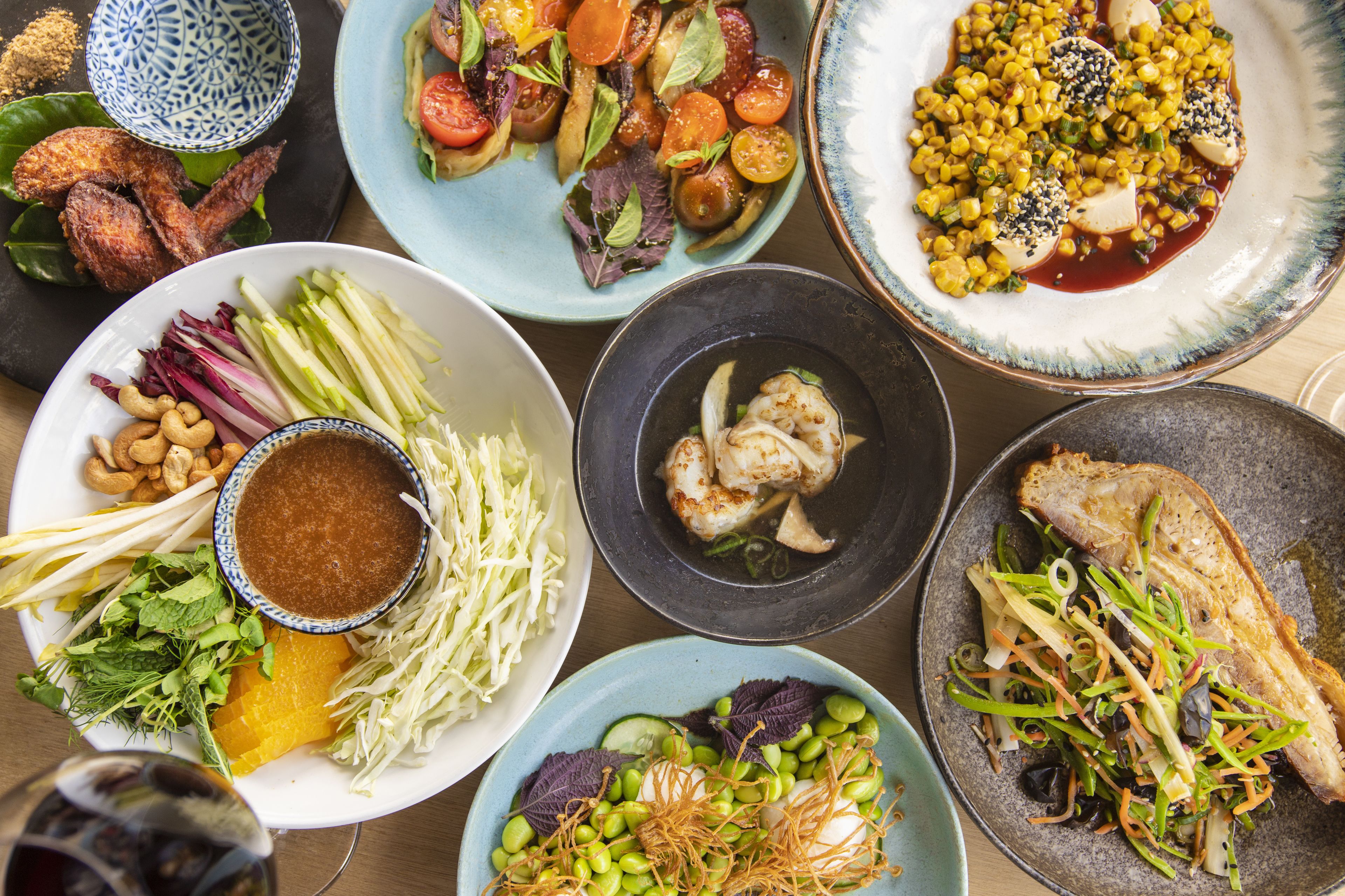 A variety of dishes on a table, including salads, vegetables, and meat.