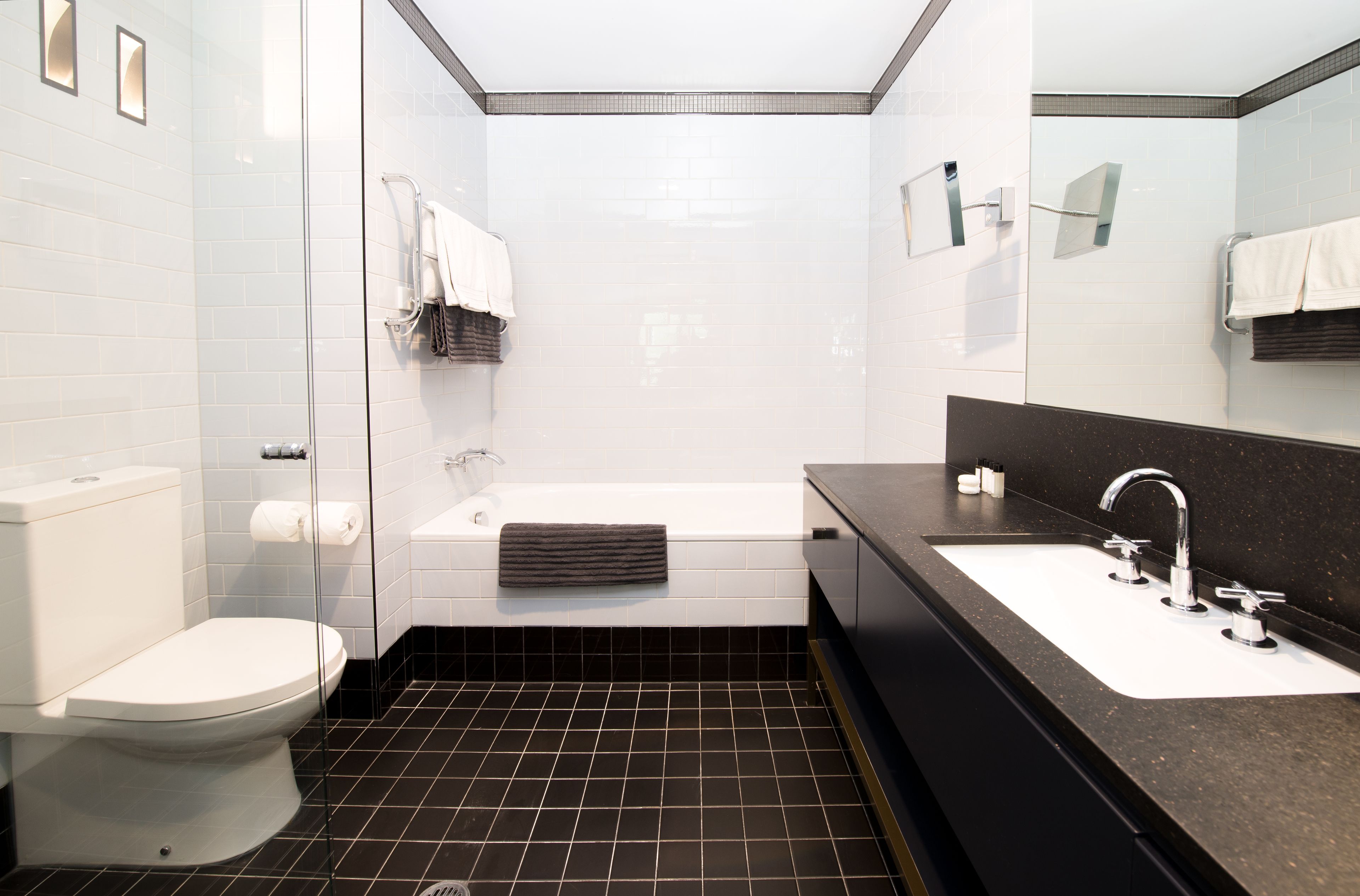 A modern bathroom with a toilet, bathtub, and sink.