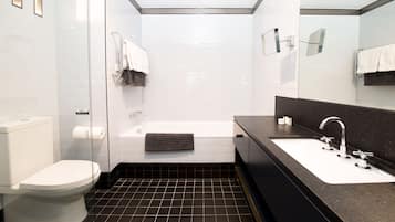 A modern bathroom with a toilet, bathtub, and sink.