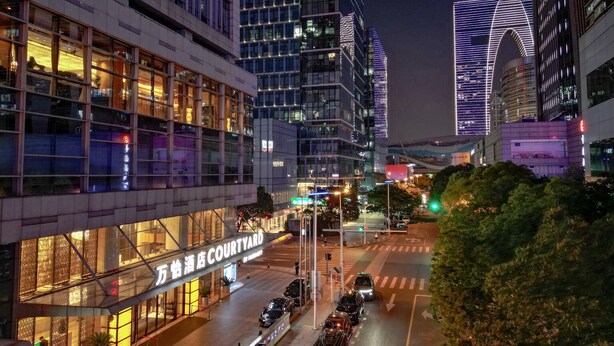 A modern building with a glass facade and illuminated signage. - Courtyard by Marriott Suzhou (Suzhou)