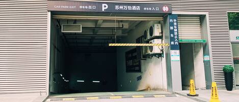 A car park exit with a sign indicating the entrance to a hotel.