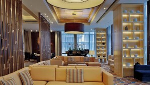 A modern hotel lobby with a large round table, sofas, and a decorative ceiling light. - Courtyard by Marriott Suzhou (Suzhou)