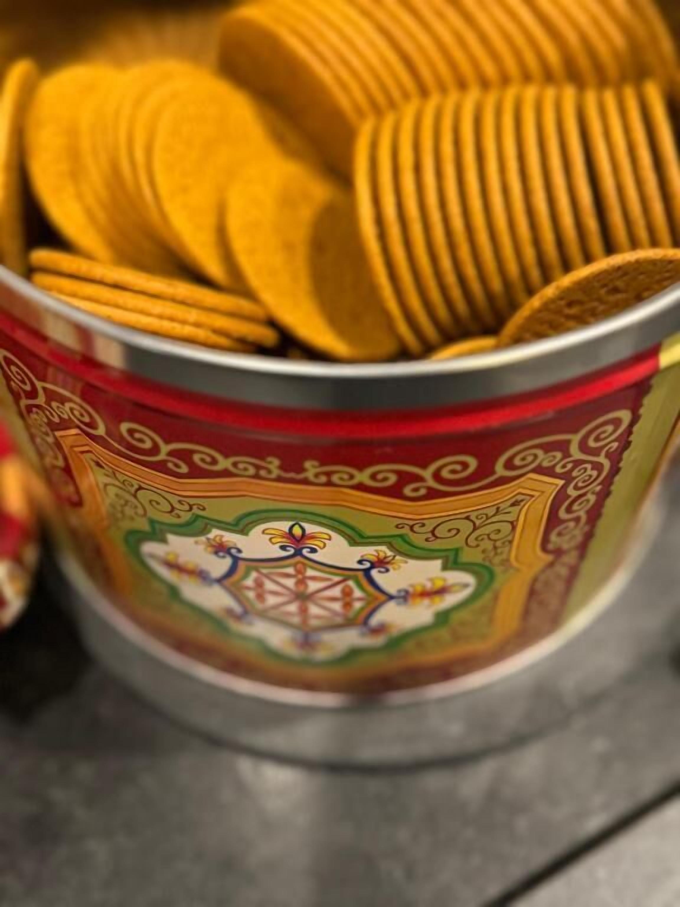 A can of yellow crackers with a decorative label.