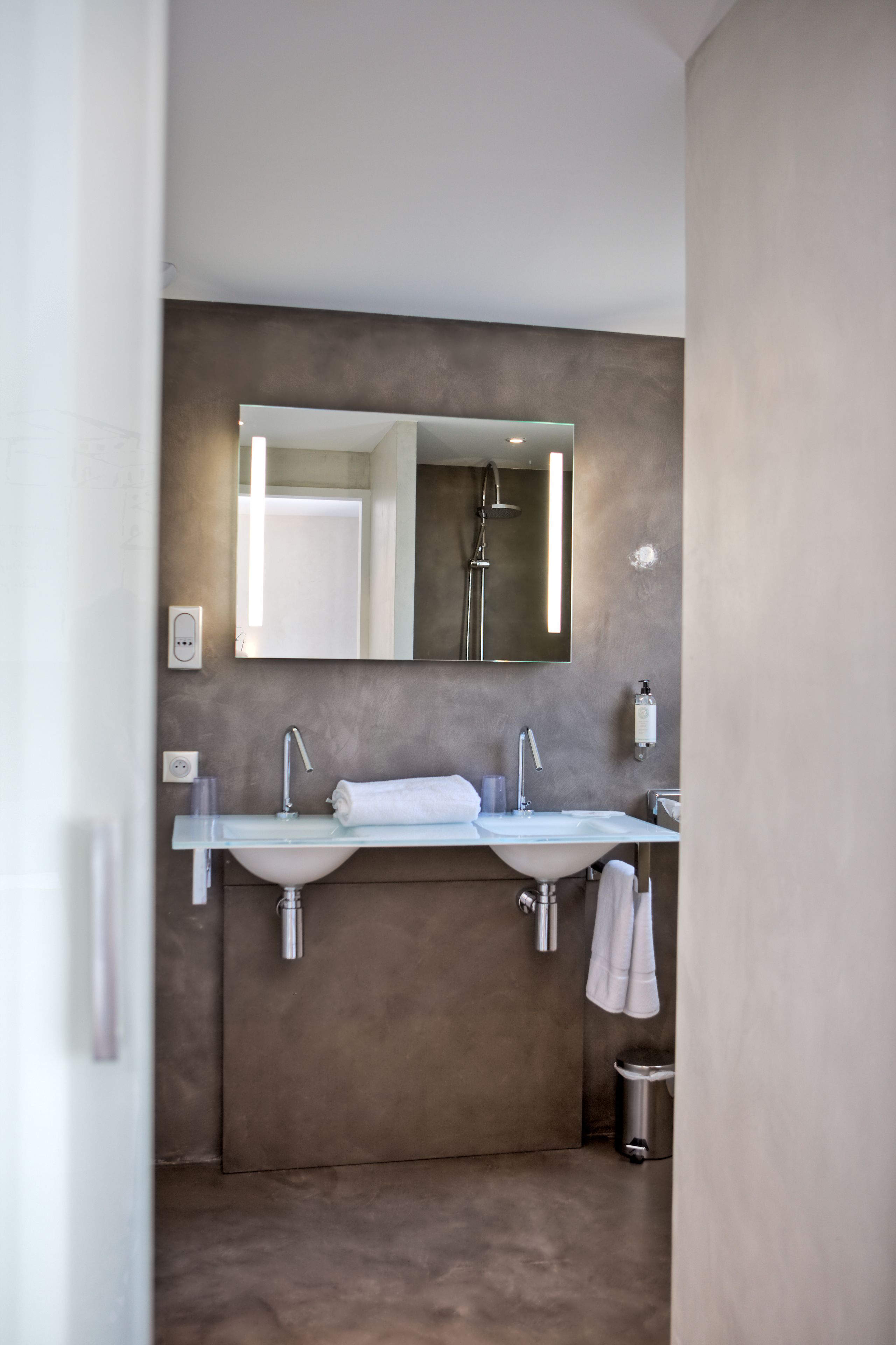 Un baño moderno con dos lavamanos, un espejo grande y una ducha.