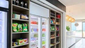 A well-stocked beverage refrigerator with various drinks and snacks. - Abode Gungahlin (Gungahlin)