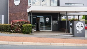 A modern building with a sign reading "abode" and "ENTRY" on the front. - Abode Gungahlin (Gungahlin)