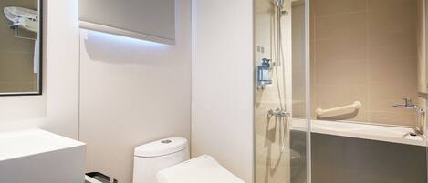 A modern bathroom with a glass-enclosed shower, a white toilet, and a large sink.