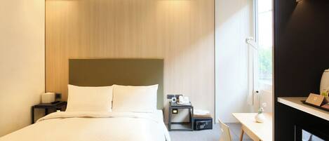 Une chambre d’hôtel moderne avec un grand lit, des tables de chevet, un bureau et une chaise.
