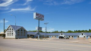 A North Country Inn with a large sign, multiple motel units, and a clear blue sky.