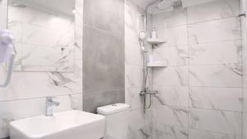 Une salle de bain moderne avec un lavabo, des toilettes et une douche en marbre.