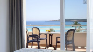 Ein Balkon mit Tisch, Stühlen und Blick auf das Meer.