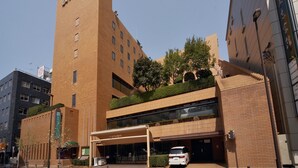 A modern hotel with a prominent tower and a covered entrance. - Fukuoka Garden Palace (Fukuoka)