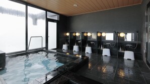 A modern bathroom with a large hot tub, multiple sinks with round lights, and a view of the outdoors. - Candeo Hotels Kameyama (Kameyama)